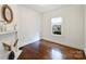 Neutral bedroom with hardwood floors, a decorative fireplace, and a bright window with exterior views at 1417 The Plz, Charlotte, NC 28205