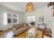 Cozy living room features hardwood floors, a decorative pendant light, and a view into the dining room at 1417 The Plz, Charlotte, NC 28205