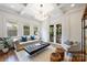 Airy living room with large windows, a comfortable sofa, and access to the outdoor patio at 1417 The Plz, Charlotte, NC 28205