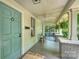 Inviting covered porch with ceiling fans, brick columns, and ample space for outdoor seating at 1417 The Plz, Charlotte, NC 28205