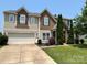 Beautiful two-story home showcasing a manicured lawn, stone accents, and an attached two-car garage at 15105 Cavanshire Trl, Charlotte, NC 28278
