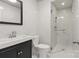 Modern bathroom showcasing white tile, glass enclosed shower, and a sleek black vanity at 1517 E Barden Rd, Charlotte, NC 28226
