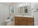 Traditional bathroom featuring a window, neutral walls, a wood vanity, and framed mirror at 1517 E Barden Rd, Charlotte, NC 28226