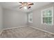 Bedroom featuring two windows, neutral walls, neutral carpet and a modern ceiling fan at 1517 E Barden Rd, Charlotte, NC 28226