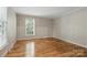 Bright bedroom with hardwood floors, a neutral paint color, and a large window at 1517 E Barden Rd, Charlotte, NC 28226