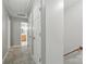 Hallway features neutral walls, carpet and white doors, leading to bathroom with wood cabinets at 1517 E Barden Rd, Charlotte, NC 28226