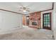 Cozy living room boasts a brick fireplace, neutral carpet, ceiling fan, and doors to the outside at 1517 E Barden Rd, Charlotte, NC 28226