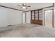 Bright living room featuring a ceiling fan, neutral carpet, white walls, and built-in wooden shelving at 1517 E Barden Rd, Charlotte, NC 28226