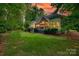 Exterior backyard view with deck and lush green lawn during a stunning sunset at 16527 Woolwine Rd, Charlotte, NC 28278