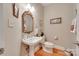 Charming powder room with a pedestal sink, ornate mirror, and hardwood floors at 16527 Woolwine Rd, Charlotte, NC 28278