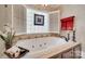 Elegant jetted tub with decorative tiles, shutters, and luxurious fixtures at 16527 Woolwine Rd, Charlotte, NC 28278