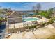 Community pool area featuring ample seating, manicured landscaping, and lake views in a gated setting at 16527 Woolwine Rd, Charlotte, NC 28278