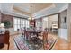 Formal dining room featuring elegant table, chandelier, wainscoting, hardwood floors, and windows for natural light at 16527 Woolwine Rd, Charlotte, NC 28278