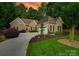 Charming brick home featuring a well-manicured lawn, a two-car garage and mature trees at 16527 Woolwine Rd, Charlotte, NC 28278
