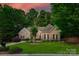 Charming brick home featuring a well-manicured lawn, a two-car garage and mature trees at 16527 Woolwine Rd, Charlotte, NC 28278