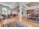 Open concept living room and dining room with hardwood floors, elegant furnishings, and abundant natural light at 16527 Woolwine Rd, Charlotte, NC 28278