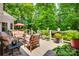 Relaxing outdoor deck with stylish patio furniture, an umbrella, and a lush green backdrop at 16527 Woolwine Rd, Charlotte, NC 28278