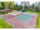 Sport courts featuring a basketball court and tennis court in a fenced in area with mature trees at 16527 Woolwine Rd, Charlotte, NC 28278