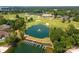 Aerial view of the golf course, lake, and club house in a neighborhood with lush tree coverage at 17719 Springwinds Dr, Cornelius, NC 28031