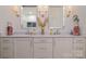 Bathroom features a marble countertop, double sinks, and decorative lighting at 17719 Springwinds Dr, Cornelius, NC 28031