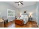 Cozy bedroom featuring hardwood floors, a ceiling fan, a window with shutters and neutral decor at 17719 Springwinds Dr, Cornelius, NC 28031