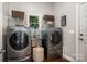 Efficient laundry room is equipped with modern machines, shelving, a utility sink, and a window for natural light at 17719 Springwinds Dr, Cornelius, NC 28031