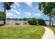 Well-manicured lawn leading to a lake with a small bench and lamp post at 17719 Springwinds Dr, Cornelius, NC 28031
