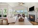 Bright living room boasts large windows with lake views and a fireplace with custom mantle and a vaulted ceiling at 17719 Springwinds Dr, Cornelius, NC 28031