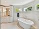 Bright bathroom featuring a soaking tub, white tile, and a vanity with storage at 2526 Sherwood Ave, Charlotte, NC 28207