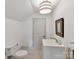 Bright white bathroom with decorative mirror, neutral tile floor, and built-in sink at 2526 Sherwood Ave, Charlotte, NC 28207