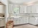 Well-lit laundry room with custom cabinets, countertops, and a farmhouse sink at 2526 Sherwood Ave, Charlotte, NC 28207