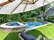 Backyard pool and hot tub with artificial turf, lounge chairs, and umbrella at 2526 Sherwood Ave, Charlotte, NC 28207
