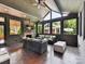 Bright sunroom with brick fireplace, multiple windows, and wicker couches with leafy pattern at 2526 Sherwood Ave, Charlotte, NC 28207