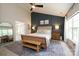 Main bedroom featuring a panel accent wall, a ceiling fan, and an en-suite bathroom at 2908 Barnard Castle Ln, Matthews, NC 28104