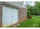 Exterior door offering access to the backyard, complemented by lush greenery and a retaining wall at 2908 Barnard Castle Ln, Matthews, NC 28104