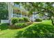 Landscaped front yard featuring a raised garden bed and a covered front porch with white railings at 2908 Barnard Castle Ln, Matthews, NC 28104