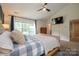 Comfortable main bedroom featuring large windows, ceiling fan, and television at 2908 Barnard Castle Ln, Matthews, NC 28104