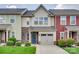 Charming townhouse featuring a stone facade, blue front door, and attached one-car garage at 318 Willow Wood Ct, Matthews, NC 28104