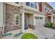 Close-up of a townhouse with stone accents, a blue door with wreath, and an attached garage at 318 Willow Wood Ct, Matthews, NC 28104