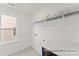 Functional laundry room features tile flooring and shelving at 32612-B Millingport Rd # 7157, New London, NC 28127