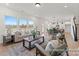 Open-concept living room with large windows, modern furniture, and wood flooring at 32612-B Millingport Rd # 7157, New London, NC 28127