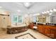 A lavish bathroom features tile surround soaking tub, double vanity, and tiled flooring at 3324 Greenhurst Dr, Matthews, NC 28104