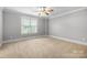 A neutral colored bedroom features carpet flooring and a ceiling fan at 3324 Greenhurst Dr, Matthews, NC 28104