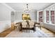 Dining room featuring hardwood floors, chandelier, and large bay windows with decorative trim and modern art at 3324 Greenhurst Dr, Matthews, NC 28104