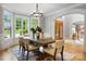 Dining room with hardwood floors, chandelier, six chairs, large bay windows and arched entry to foyer at 3324 Greenhurst Dr, Matthews, NC 28104