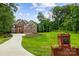 Beautiful brick home boasts lush lawn, landscaping and long paved driveway at 3324 Greenhurst Dr, Matthews, NC 28104