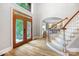 Welcoming foyer with hardwood floors, staircase, and an ornate glass-paneled front door, creating a bright and inviting entrance at 3324 Greenhurst Dr, Matthews, NC 28104
