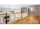 Upstairs hallway with hardwood floors and views into the living room, highlighting the home's open layout at 3324 Greenhurst Dr, Matthews, NC 28104
