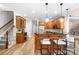 Open kitchen with breakfast bar seating, modern lighting, stainless appliances and hardwood flooring at 3324 Greenhurst Dr, Matthews, NC 28104
