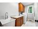 Functional laundry room with updated cabinets, sink, countertop, and modern washer and dryer units at 3324 Greenhurst Dr, Matthews, NC 28104